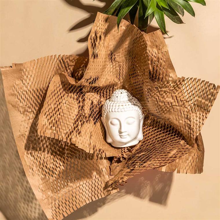 Honeycomb kraft paper wrap cushioning a ceramic figurine